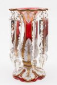 A Bohemian red and white overlay table lustre: of typical bulbous form with flaring neck with white