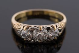 A late 19th century gold and diamond three-stone ring: with round old brilliant-cut diamonds