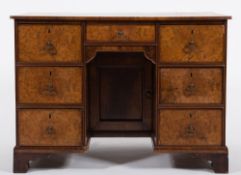A walnut veneer and feather banded rectangular kneehole desk:,