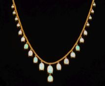 A gold and opal fringe necklace: with 22 graduated, oval opals approximately 18gms gross weight.