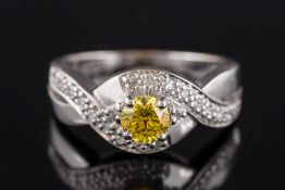 An 18ct white gold, yellow diamond & diamond cluster cross-over ring:, the treated yellow diamond 4.