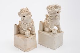 Two Chinese blanc de Chine incense stick holders: each in the form of a seated Buddhist lion dog