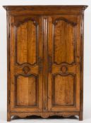 An 18th Century French Provincial oak armoire:, with a moulded and rounded cornice,