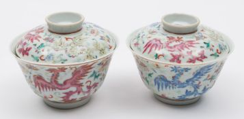 A pair of Chinese famille rose 'phoenix' bowls and covers: each painted with three phoenix in