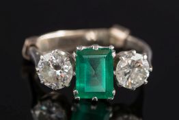 A platinum, emerald and diamond three-stone ring: with central emerald-cut emerald approximately 8.