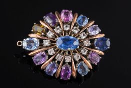 A Ceylon sapphire mounted oval brooch: with central oval blue sapphire within a frame of small