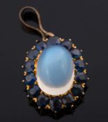 A moonstone and sapphire mounted oval cluster pendant:,