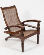 A 19th Century Anglo Indian teak planters chair:, with curved cane panel folding back,
