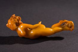 A late 19th century carved amberoid pipe stem:, in the form of a nude female figure,