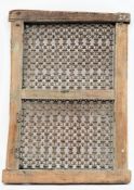 An 18th century shuttered window:, the wooden frame enclosing two cast iron trellis panels,