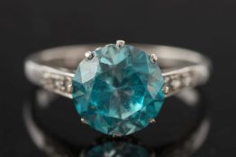 An 18ct white gold, platinum and blue zircon single-stone ring:, the circular blue zircon 9.
