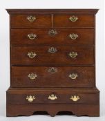 An 18th Century oak chest on a low stand:, the upper part with a moulded cornice,