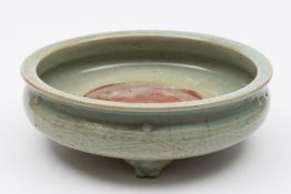 A Chinese Longquan celadon tripod censer: of compressed circular form,