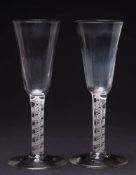 A pair of opaque twist ale glasses: the funnel shaped bowl with basal ribs on a straight double