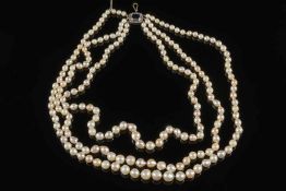 A graduated cultured pearl three strand necklace: with blue and white paste-set clasp.