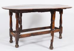 An 18th Century oak gateleg table:, with an oval hinged top,