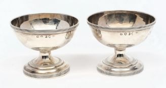 A pair of George III silver circular pedestal salts, maker's mark worn, London,