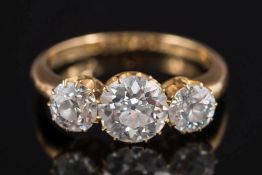 An early 20th Century gold and diamond mounted three-stone ring: with central round,