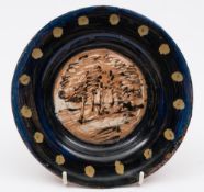 Quentin Bell, a pottery dish: the centre painted with a line of trees in a landscape,
