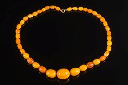 A graduated amber coloured bead single string necklace: with 41 graduated amber coloured beads,