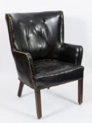 A late 19th Century mahogany frame and leather upholstered tub-shaped wing armchair:,