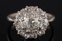 A diamond mounted circular cluster ring: with central,