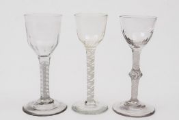 Three various opaque twist wine glasses: two with ogee shaped bowls with basal fluting set on