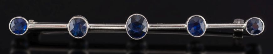 A white gold and sapphire five-stone bar brooch: stamped '9ct' with graduated, oval sapphires,
