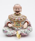 A Continental nodding-head pagoda figure in the Meissen style: the smiling figure seated