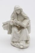 An early Bow white figure of a seated nun: wearing a hooded cloak over elaborate robes and reading