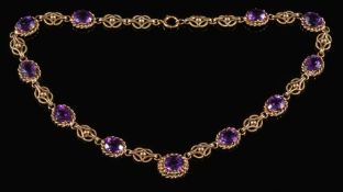 A 9ct gold and amethyst oval-link necklace: with 11 oval amethysts within rope-twist design links,