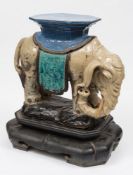 A pair of large Chinese stoneware elephant-form garden seats: each caparisoned elephant with trunk