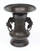 A Chinese bronze wine vessel:, of waisted form, with grape and vine leaf decorated loop handles,