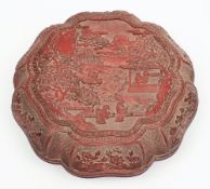 A Chinese carved cinnabar lacquer box and cover: of lobed circular form,