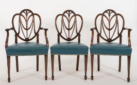 A set of eight carved mahogany dining chairs in the Hepplewhite taste:,