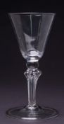 A pedestal stem wine glass: the round funnel shaped bowl with flattened knop set on a six sided
