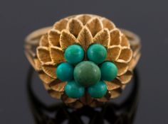A turquoise mounted circular, domed cluster ring: of pierced design, the shank stamped '750',