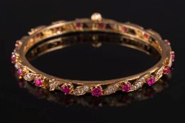 A ruby and diamond mounted hinged bangle: with round rubies separated by diamond-set scrolls and