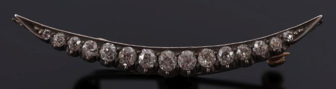 A diamond-set crescent brooch: with graduated, old-cut diamonds, approximately 46mm total length.