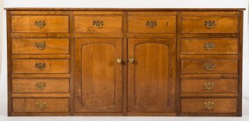 A 20th Century oak dresser base:, the top with hinged enclosed compartment to one side,