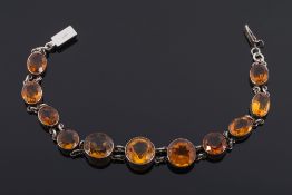 A graduated citrine mounted bracelet: with circular and oval citrines.