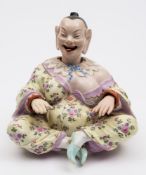 A Continental nodding-head pagoda figure in the Meissen style: the smiling figure seated
