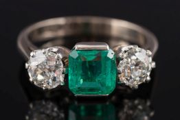 An 18ct white gold, emerald and diamond three stone ring:,