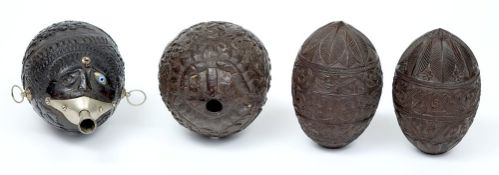 A mid 19th century carved coconut 'Bugbear' flask and three unmounted flasks: the first finely