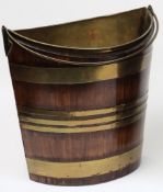 An 18th Century mahogany and brass bound navette shaped bucket:, with swing handle and brass liner.