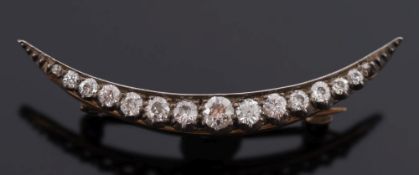 A diamond mounted crescent brooch: with graduated, old-cut diamonds,