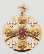 A cruciform pendant with central oval, cabochon ruby:, approximately 17gms gross weight.