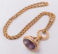 A gold and amethyst fob initialled 'R', on gilt metal, rope twist necklace:.