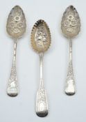 Three Georgian and later decorated silver berry spoons: various makers and dates, 6.41ozs.