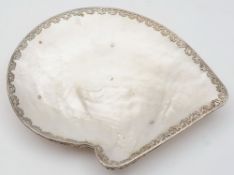 A mother-of-pearl shell and silver mounted dish: raised on three peg feet, 17cm. wide.